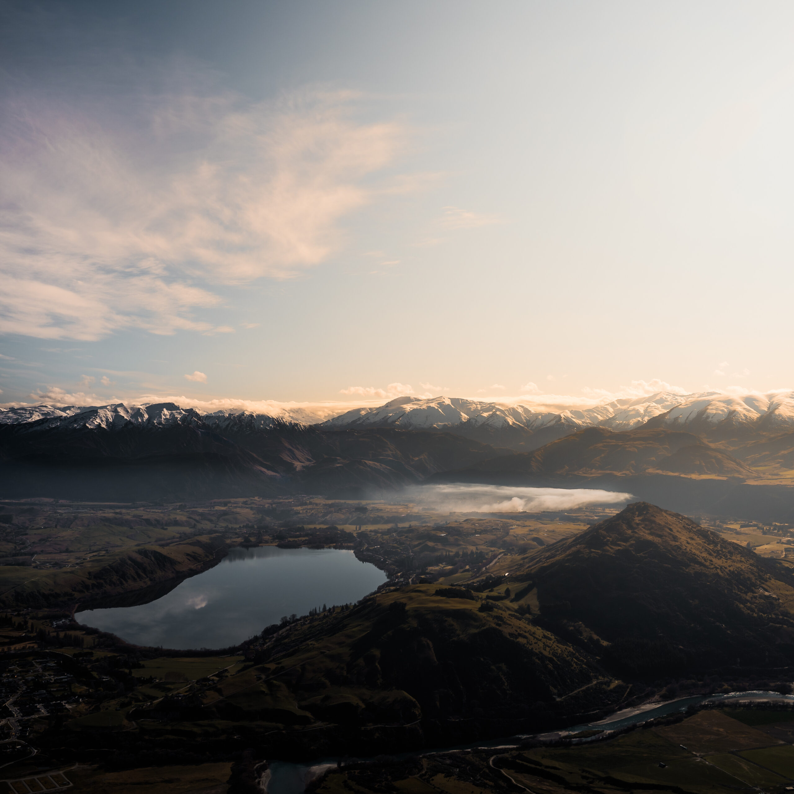 An aerial view of a mountain lake at sunset