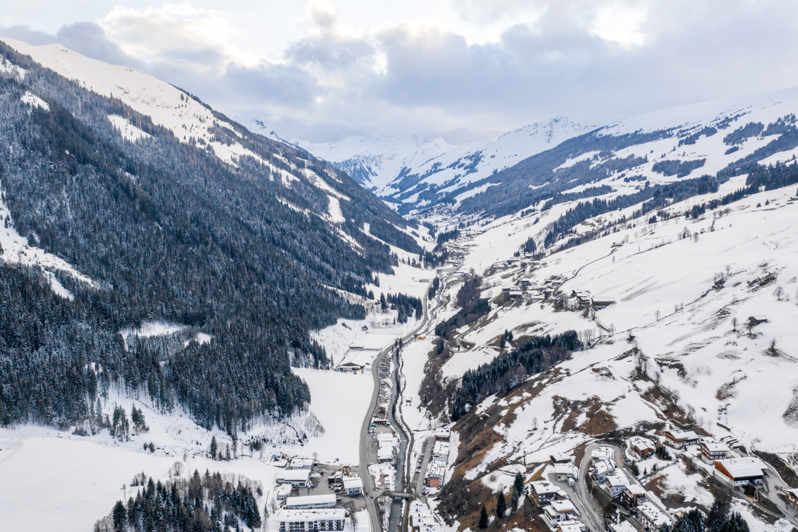 A scenic aerial shot of a town in between mountain alps